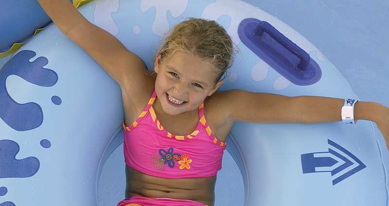 child relaxing in pool on pool float
