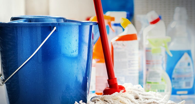 assorted cleaning products and mop bucket