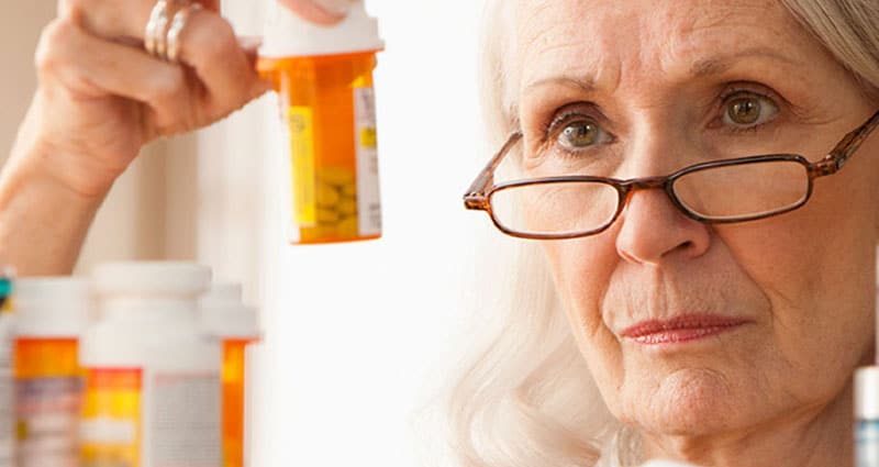 woman looking at prescription medication