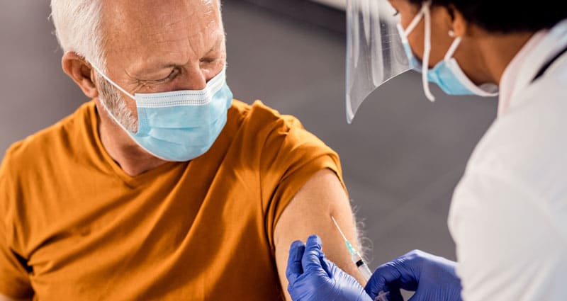 medical professional applying a shot to a man's arm