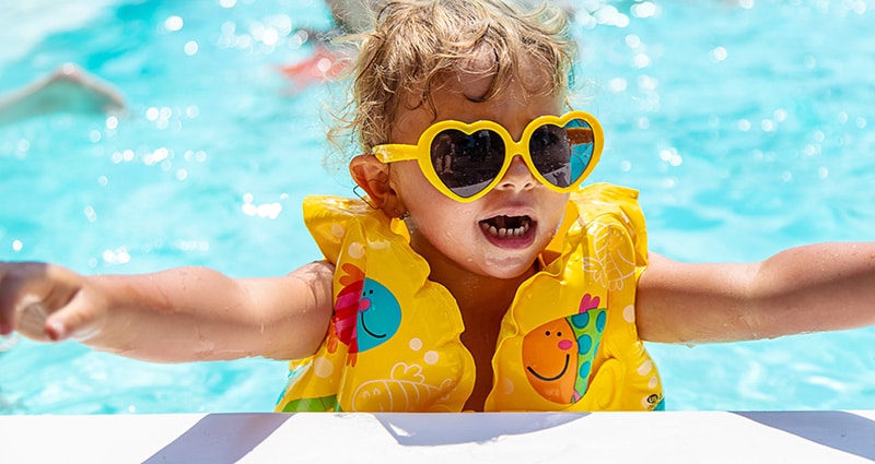 kid in pool with life jacket