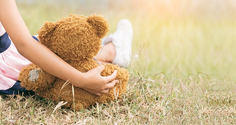 child holding teddy bear