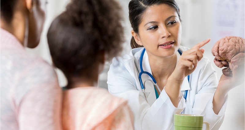 medical provider explaining brain anatomy to child and parent