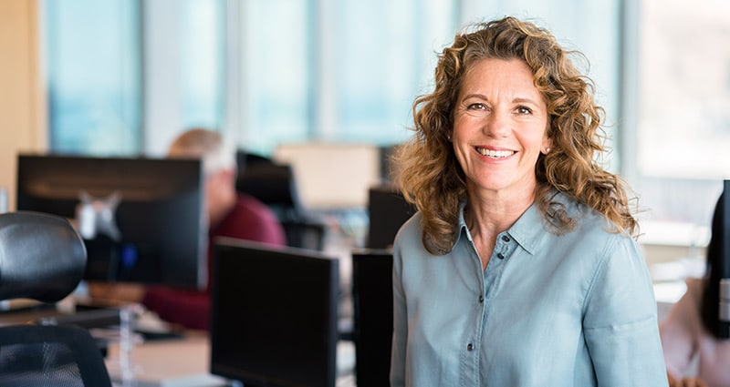 smiling woman in an open office setting