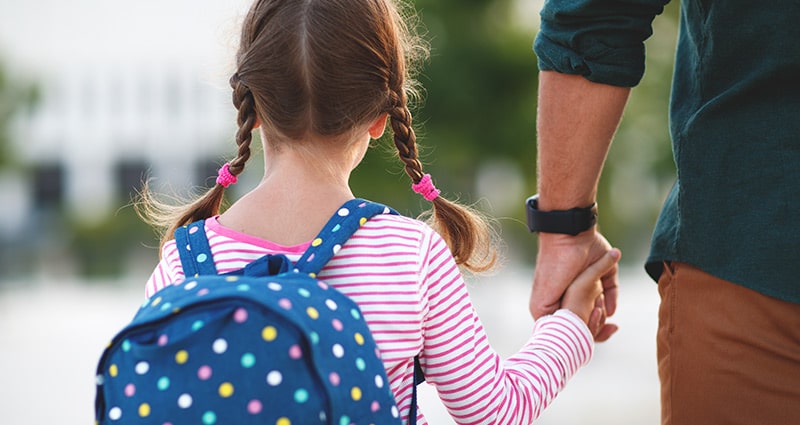 adult walking child to school