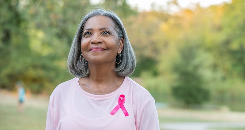 woman smiling wearing pink ribbon