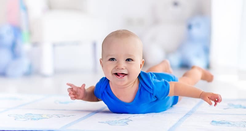 smiling baby doing tummy time