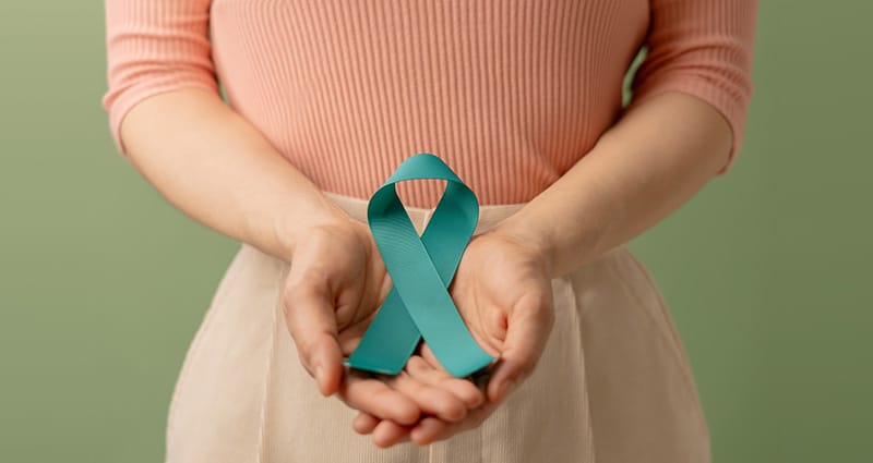 woman holding teal ribbon