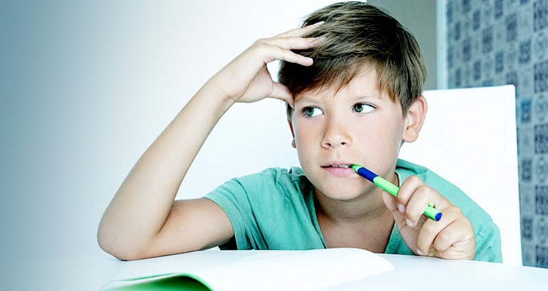 kid thinking while doing homework