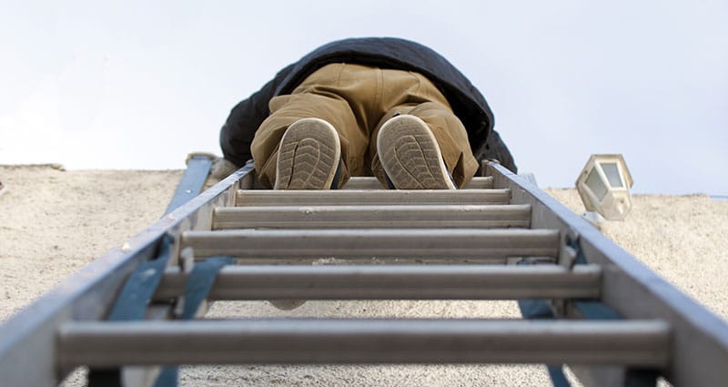 person climbing to the top of a ladder outdoors