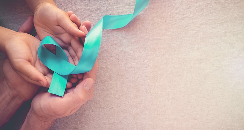 hands holding teal ribbon