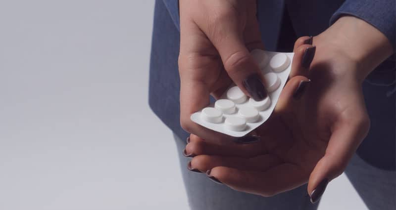 Person holding pack of pills