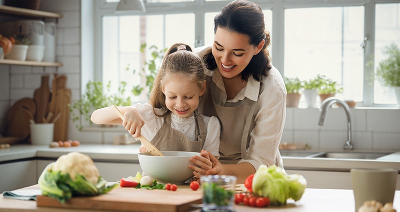 mom and kid working together in kitchen