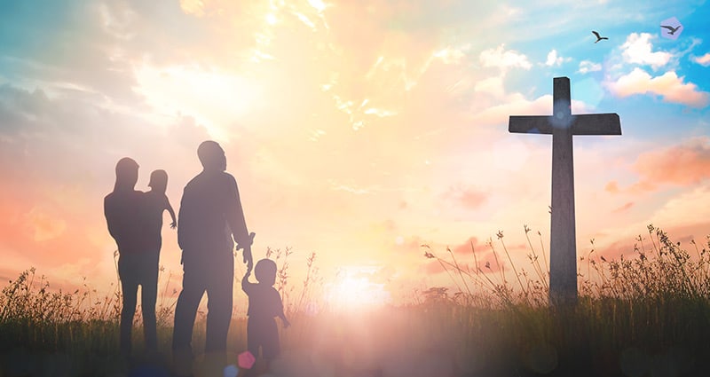 adult and child looking at cross