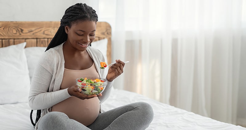 Pregnant woman eating a salad