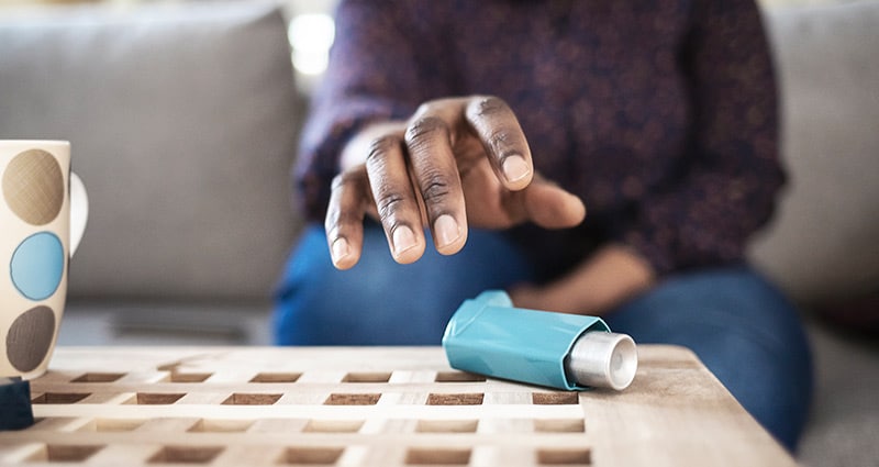 man reaching for asthma inhaler