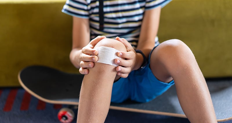 tween putting bandage on knee