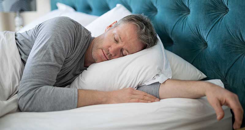 man sleeping on pillows