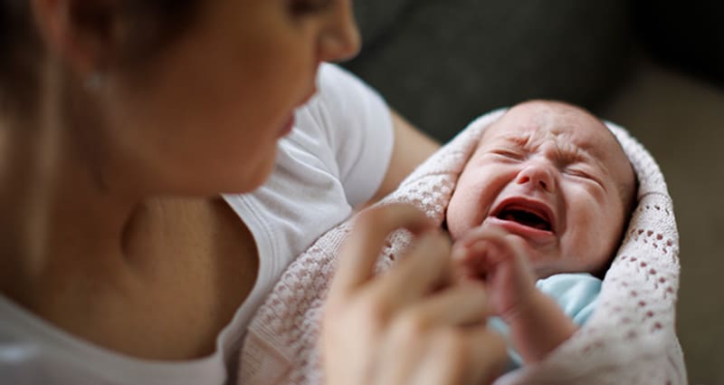 crying baby being soothed by parent