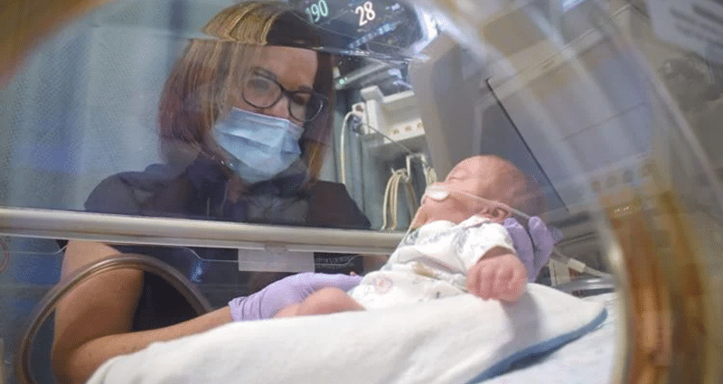 Medical professional looks in on newborn