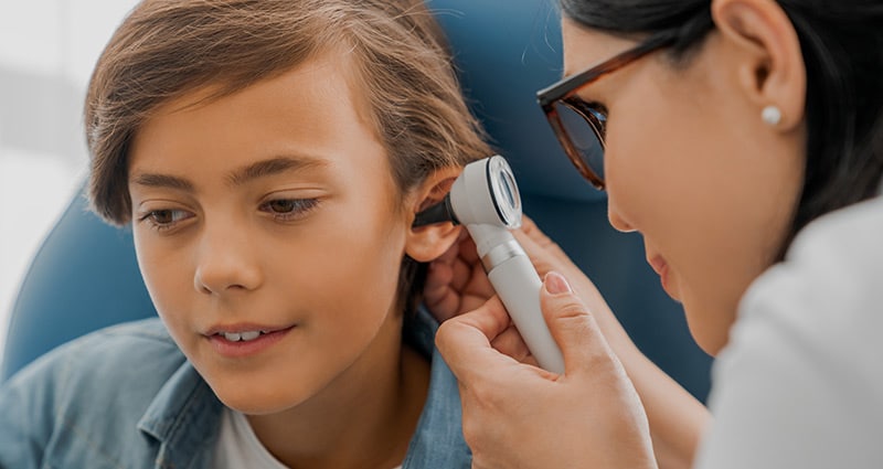 child getting ear checked by medical professional