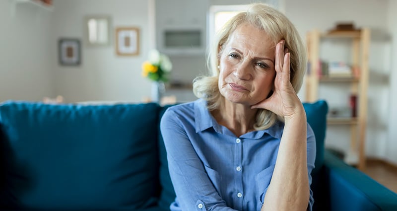 woman holding her head looking confused