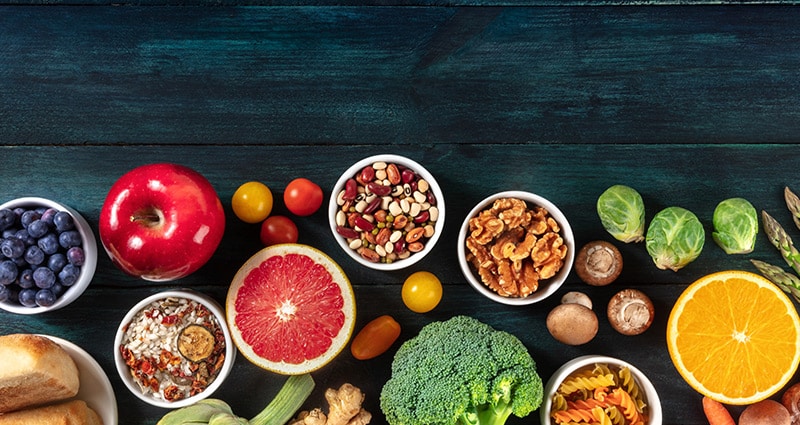 fruits, vegetables and nuts on black background