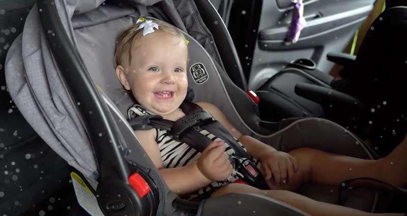 happy infant sitting in car seat