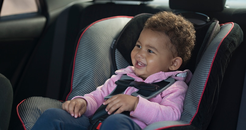 smiling kid in car seat