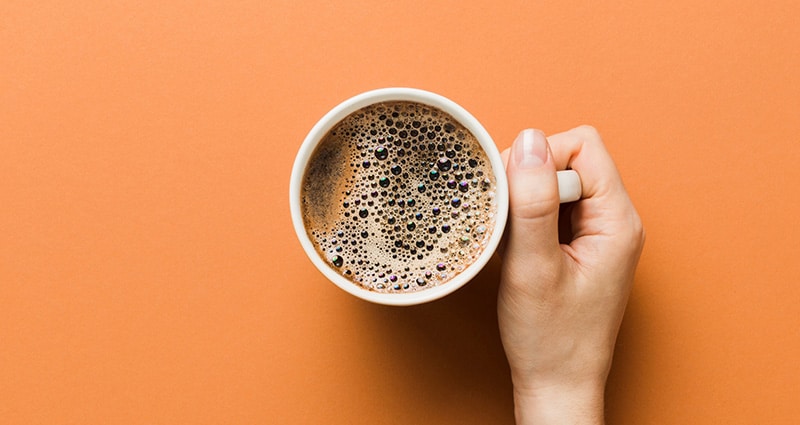 cup of coffee on orange background