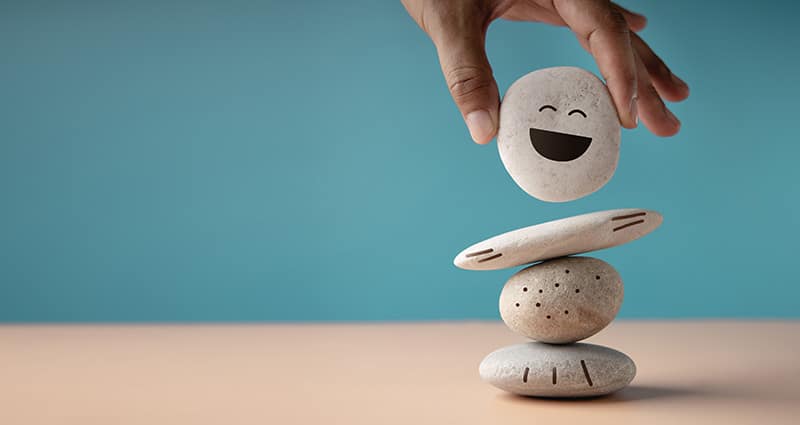 stacked rocks, one with smiley face