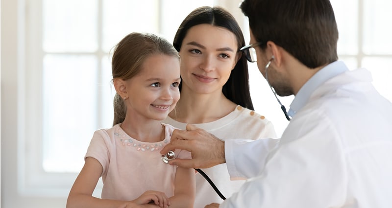 Doctor listening to child's heart