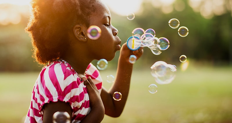 child blowing bubbles