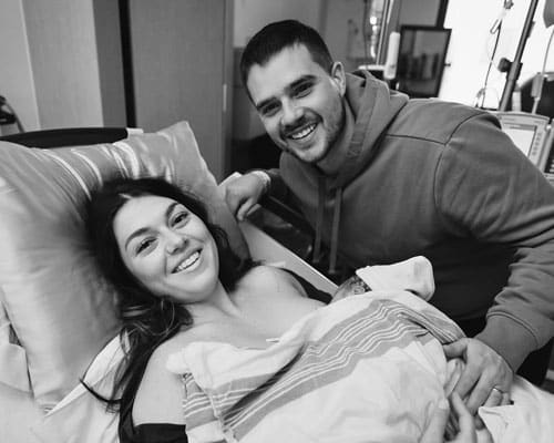 mother and father posing with newborn shortly after delivery