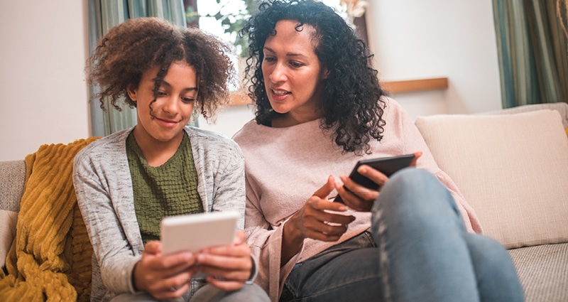 mom and daughter looking at phones together