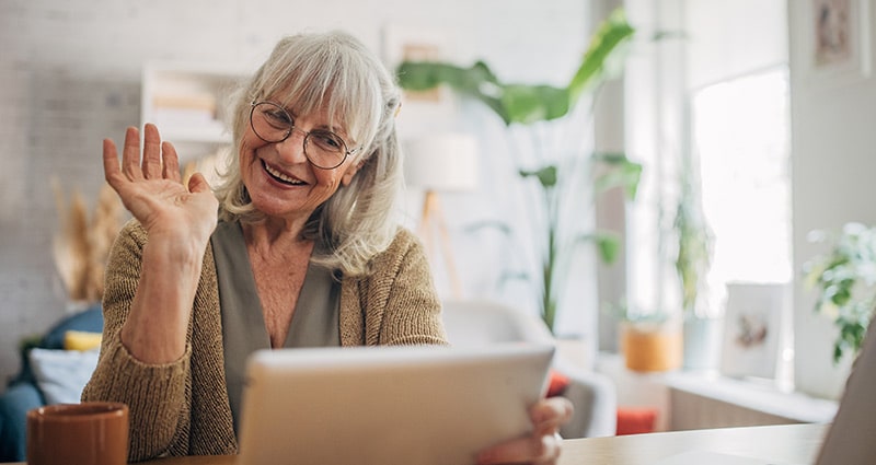 Older woman waving on a video call