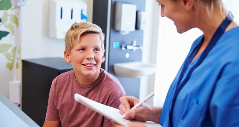 happy boy speaking with medical professional