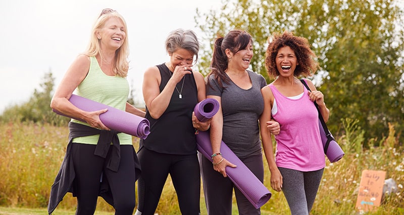 group of women walking outdoors with exercise equipment