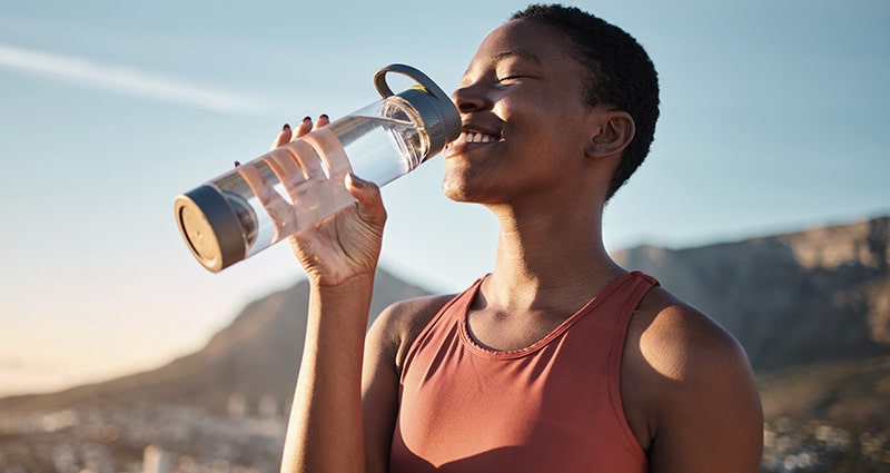 woman drinking water outdoors