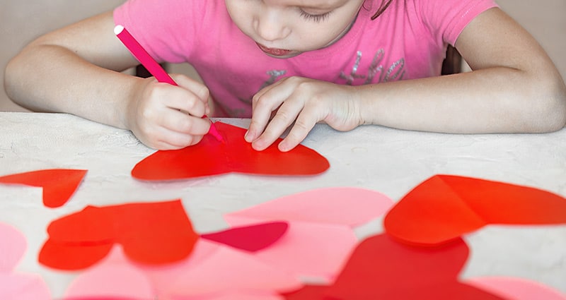 child working on heart arts and crafts project