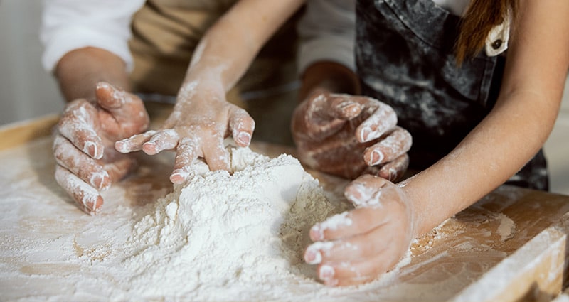 parent and child working on pie dough together