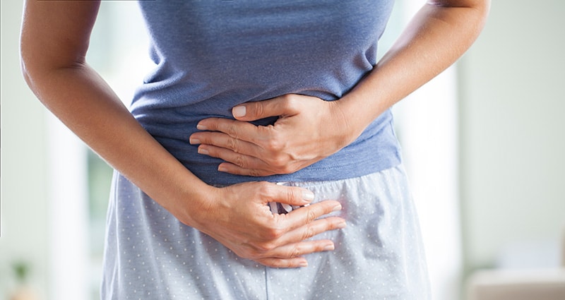 person holding stomach to indicate pain