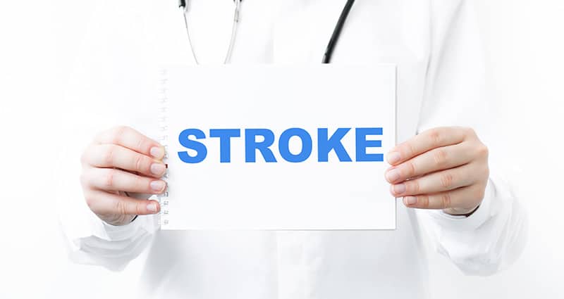 provider holding paper with STROKE in bold blue letters