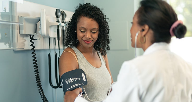 provider taking woman's blood pressure
