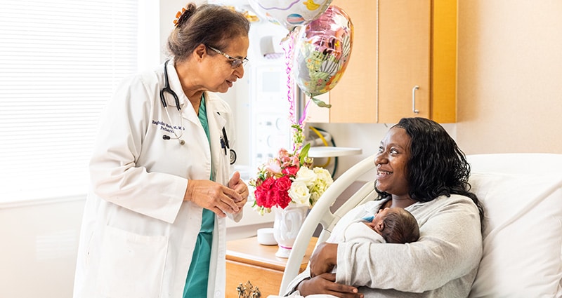 Dr. Mangat speaking to new mom holding her newborn